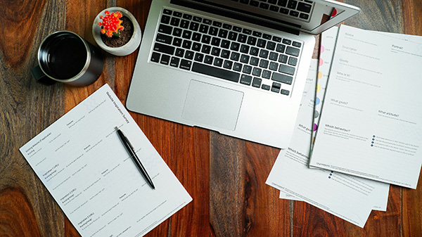 Computer next to paperwork